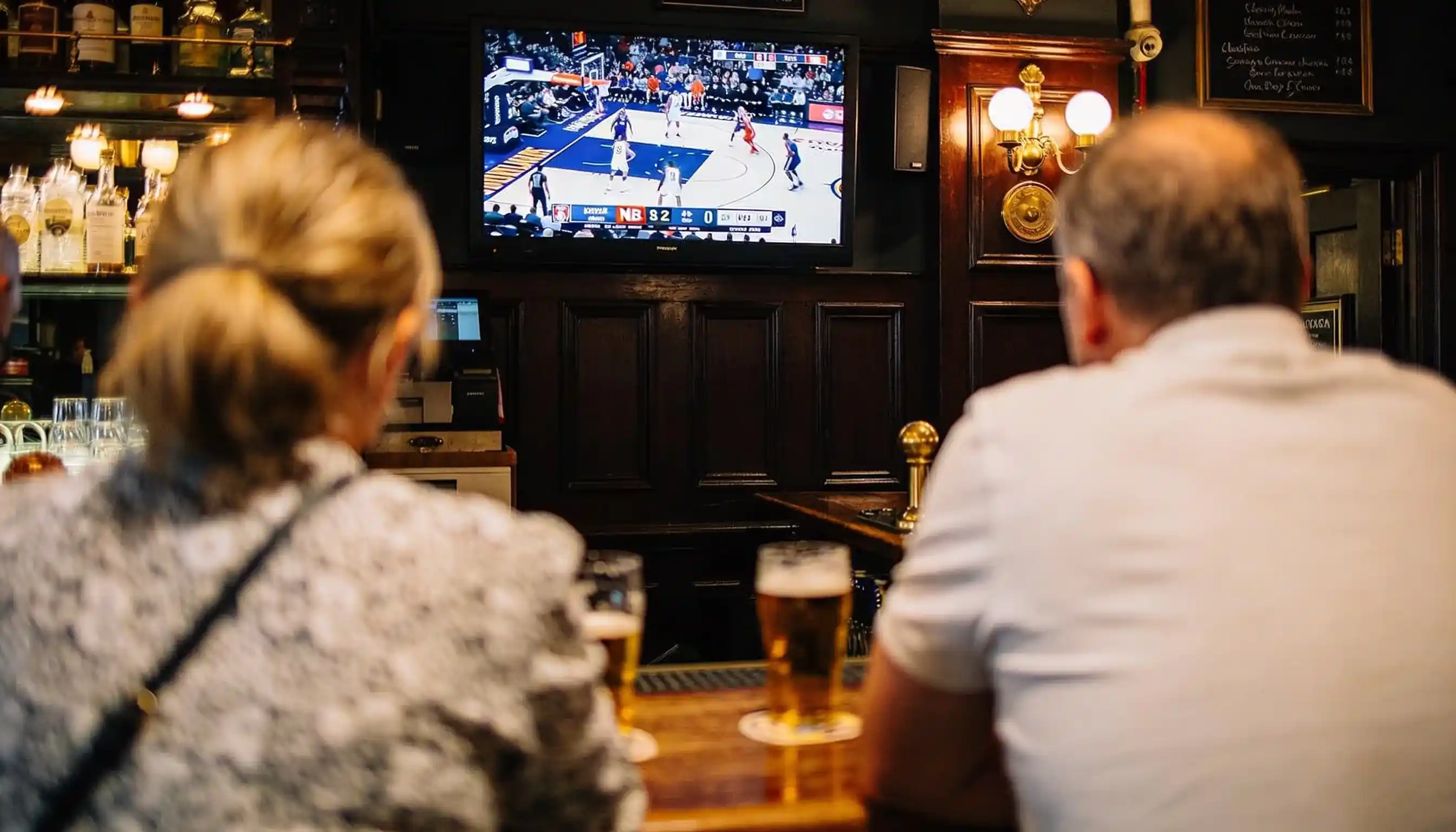 UK basketball fans watching an NBA game on a pub television in 2026